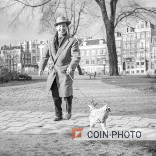 Photo d'un homme promenant son coq "Coco" dans les rues d'Amsterdam en 1951