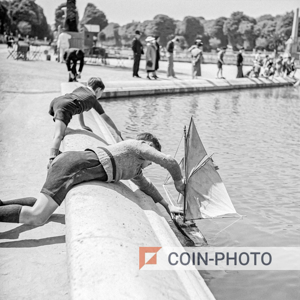 Photo d’enfants jouant aux bateaux au jardin du Luxembourg en 1948