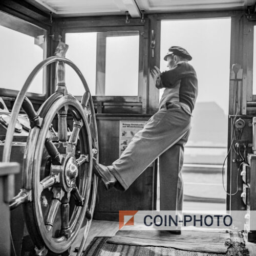 Photo du skipper Anton Rieb tenant la barre avec son pied en 1955
